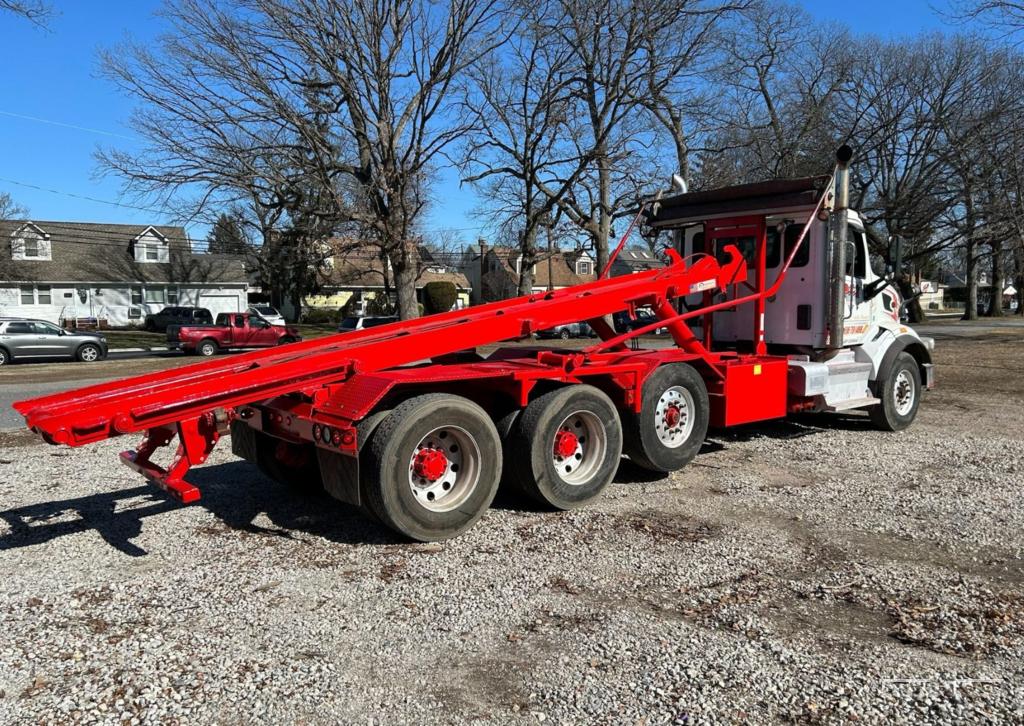 ### Key Elements **Main Subject** - Red truck with a hydraulic arm. **Notable Features** -